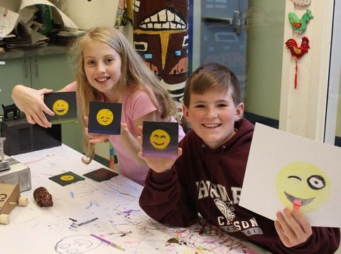 boy and girl drawing smiley faces